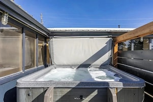 Un jacuzzi con terraza de madera y baranda metálica.