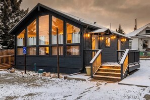 A cabin with large windows, a wooden deck, and a wheelchair-accessible entrance.