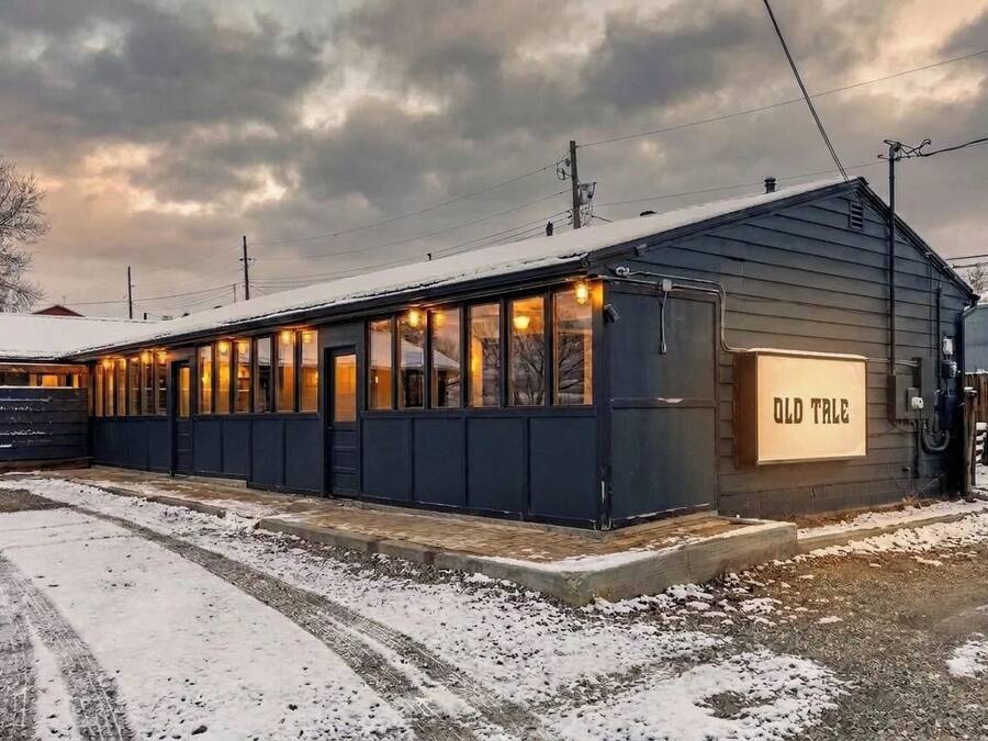A small, single-story building with a dark exterior and a sign reading 'OLD TALE.'