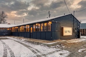 A small, single-story building with a dark exterior and a sign reading 'OLD TALE.'
