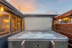A hot tub with a view of a building through the windows.