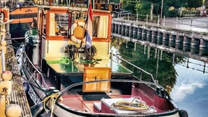 Un barco fluvial atracado en un puerto deportivo con una placa que dice "Bunde".