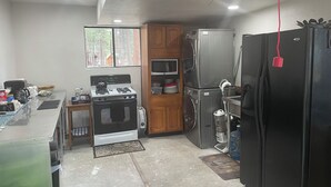 Cocina compacta equipada con estufa a gas, horno, microondas y refrigerador.