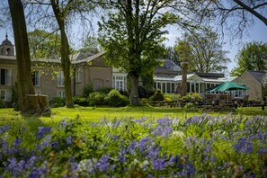 A traditional building with a conservatory, surrounded by a well-maintained garden with purple flowers. - Normanton Park Hotel, Sure Hotel Collection by Bes (Oakham)
