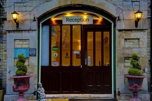 A reception area with a sign, two potted plants, and a statue. - Normanton Park Hotel, Sure Hotel Collection by Bes (Oakham)