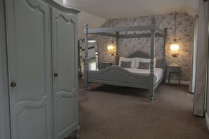 A four-poster bed with a nightstand, a dresser, and floral wallpaper. - Normanton Park Hotel, Sure Hotel Collection by Bes (Oakham)