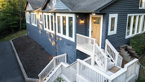 Une maison à deux étages avec un porche à l’avant, un escalier et une allée.