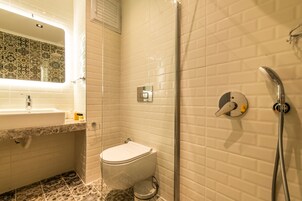 Un baño con inodoro, lavamanos y ducha.