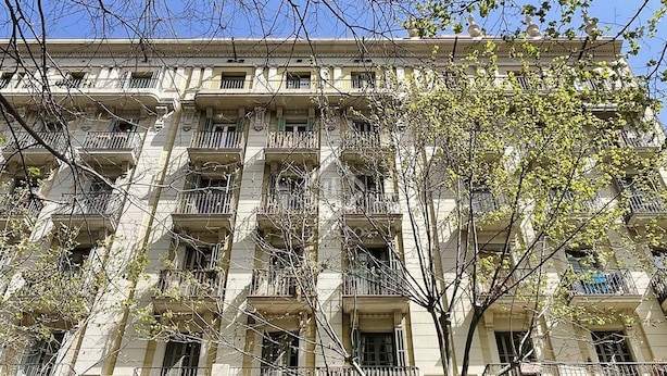 Un immeuble à plusieurs étages, doté de balcons, de grandes fenêtres et d’un style architectural classique.