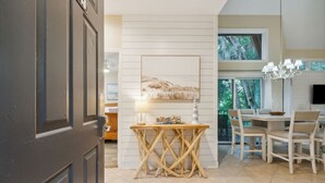 A dining area with a wooden table and chairs, a chandelier, and a painting on the wall. - *NEW* Pool, walk to Beach and 10 hole golf course! (Fernandina Beach)