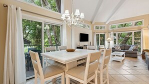A spacious living room with a dining area, large windows, and a chandelier. - *NEW* Pool, walk to Beach and 10 hole golf course! (Fernandina Beach)