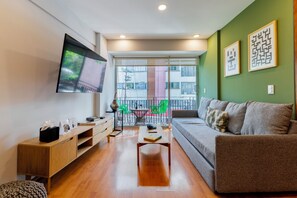 Appartement Deluxe, balcon (301) | Coin séjour | Télévision à écran plat de 50 pouces avec chaînes par câble