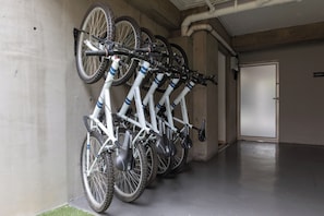 Eine Reihe von Fahrrädern, die an einer Wand in einer Parkgarage geparkt sind.