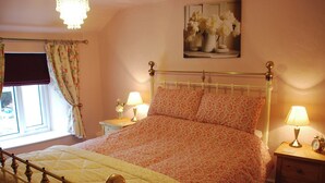 A bedroom with a bed, two bedside tables, a nightstand, a window with curtains, and a chandelier. - 2 bedroom accommodation in Youlgreave near Bakewell (Youlgreave near Bakewell)