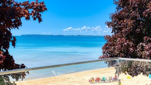 A beach view with a clear sky, a sandy beach, and a few beach chairs. - Long Beach Resort (Wainfleet)