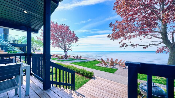 A wooden deck with outdoor seating and a view of the sea. - Long Beach Resort (Wainfleet)
