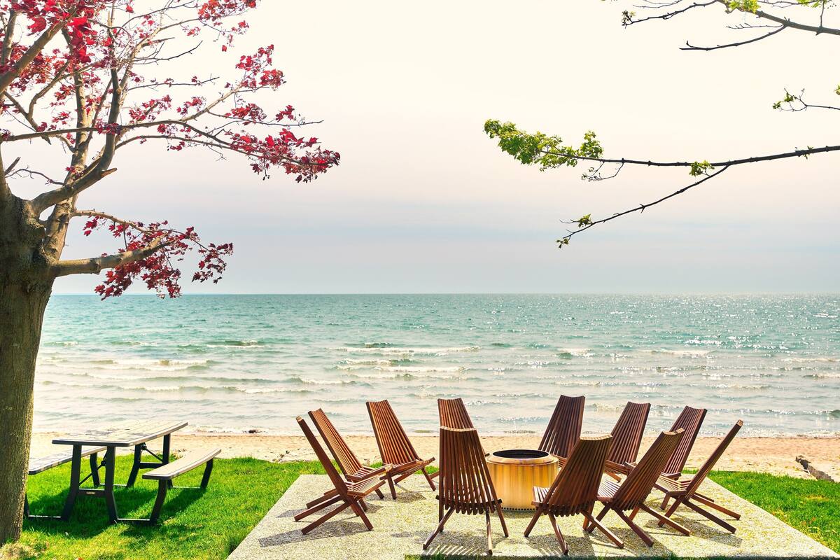 A beachside seating area with a table and chairs, overlooking the ocean.