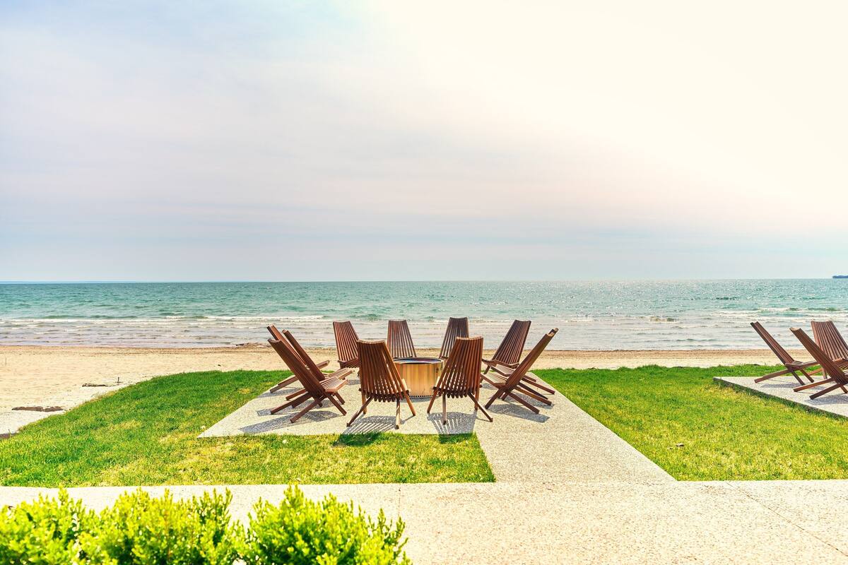A beachside seating area with a table and chairs, overlooking the ocean.
