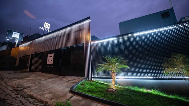 A modern building with a prominent 'DROPS' sign, a gated entrance, and a well-lit facade. - Drops Motel Campinas (Campinas)
