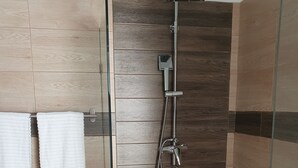 A glass-enclosed shower area with a handheld showerhead and a wall-mounted faucet. - St. penthouse w/jacuzzi (Sosúa)