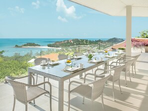 Enjoy al fresco dining with a view of the ocean and coastal landscape from this outdoor dining area.