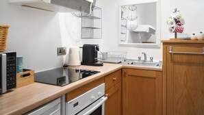 A modern kitchen with a built-in oven, a coffee maker, and a sink. - 1 bedroom accommodation in Stainforth near Settle (Stainforth near Settle)