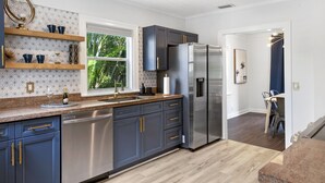 A modern kitchen with dark blue cabinets, stainless steel appliances, and a wooden countertop. - Spacious 3BR Home w/ Yard.. Steps to Golf Course (Lake Worth)