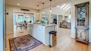 A spacious kitchen with a central island, pendant lighting, and a view into the dining area. - Private Pool, Elevator, 4-Seater Golf Cart (fee), Golf Course view- 8 Hidden Green (Isle Of Palms)