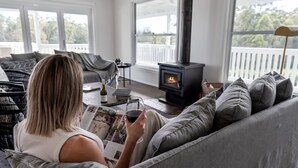 Una sala de estar acogedora con un sofá, una chimenea y un ventanal grande.