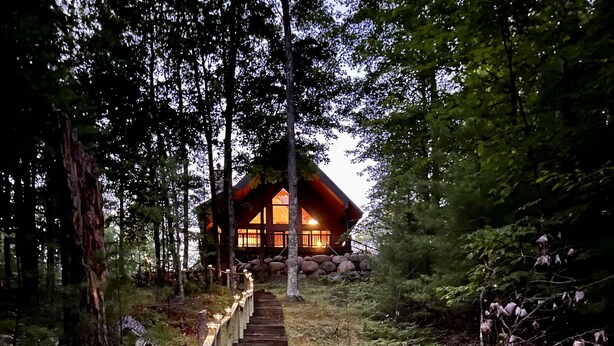 A wooden staircase leading to a lodge in a forested area. - Dog friendly, lakefront home perfect for families (Eagle River)