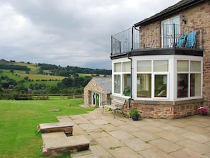 A stone house with a bay window, a small garden, and a view of rolling hills. - Shallcross Hall Cottage - Toddbrook (Whaley Bridge near Buxton)