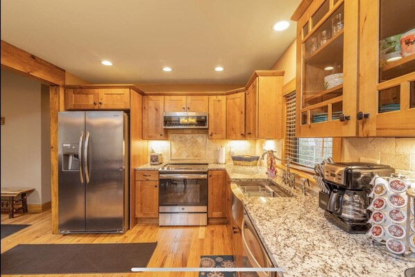 Enjoy cooking in this well-equipped kitchen with a refrigerator, oven, microwave, and sink.