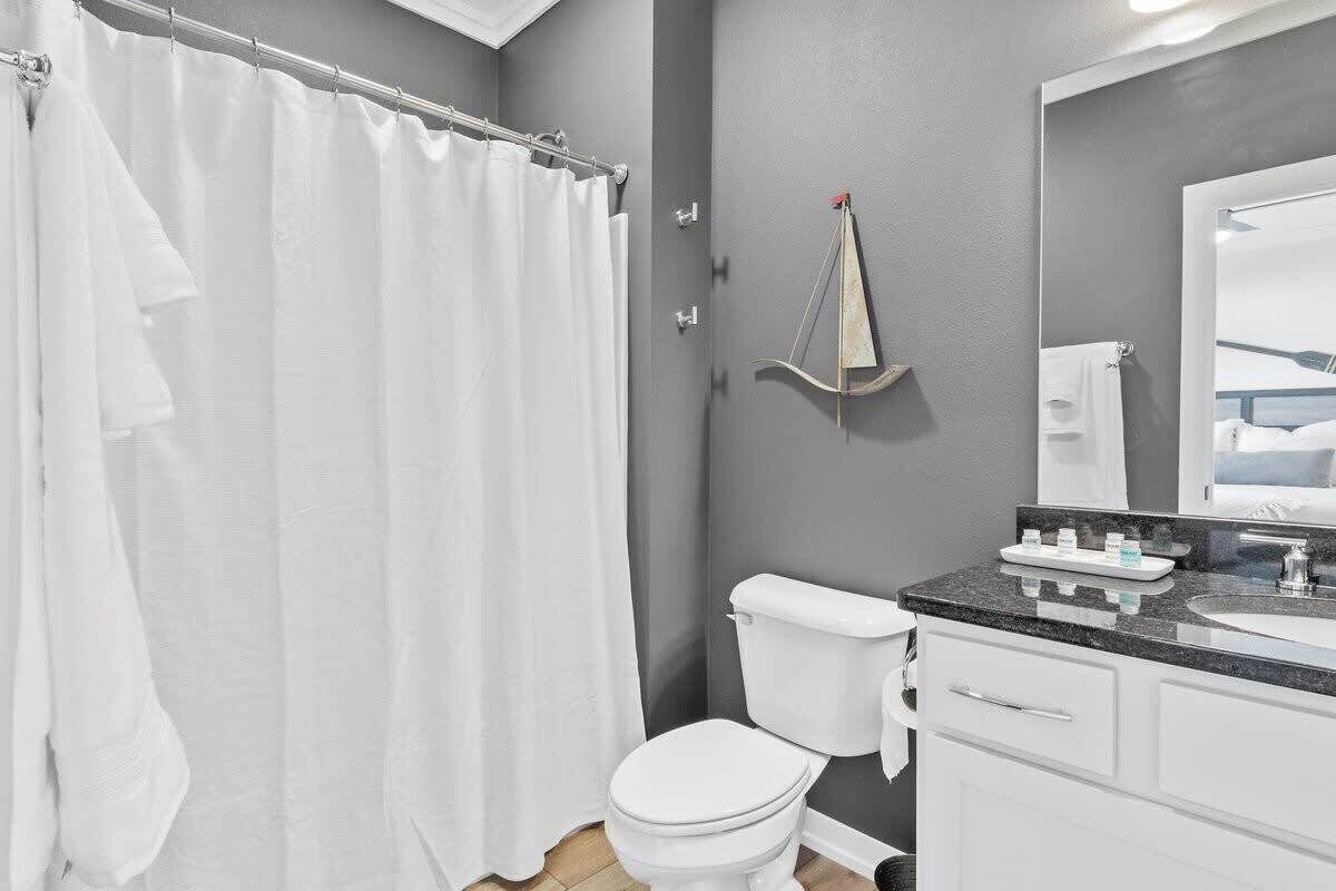 A bathroom with a white toilet, a sink, and a shower curtain.