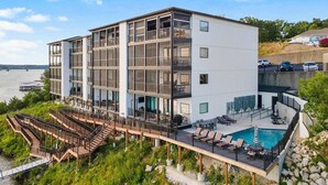 Un hôtel à plusieurs étages doté d’une piscine, d’un espace extérieur aménagé et offrant une vue sur l’eau.