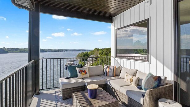 Un balcon avec un canapé, des coussins et une petite table.