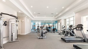 Ein Fitnessstudio mit Laufbändern, Kraftgeräten und einer Spiegelwand.
