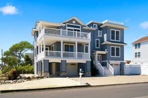 A two-story house with a balcony, a garage, and a driveway. - Awesome 5 bed, 5 bath, heated pool - short walk to the beach! (Surf City)