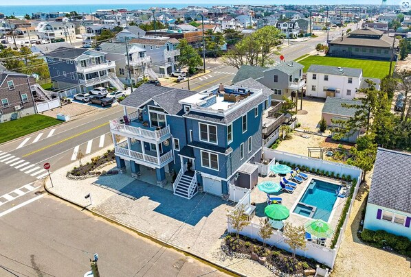 A two-story house with a balcony, a swimming pool, and a stop sign.