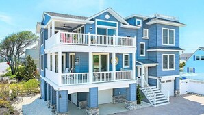 Ein zweistöckiges Haus mit Balkon, einer Veranda und einer Treppe zum zweiten Stock.