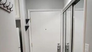 A narrow hallway with a wooden floor, a white door, and a glass door. - Cozy contemporary 1-bedroom condo with fireplace (Aurora)