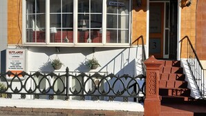 Um edifício com uma placa que diz 'Rutlands' e 'Todos os quartos com banheiro privativo'.