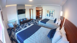 Een hotelkamer met twee bedden, een bureau, een televisie en een schilderij aan de muur.