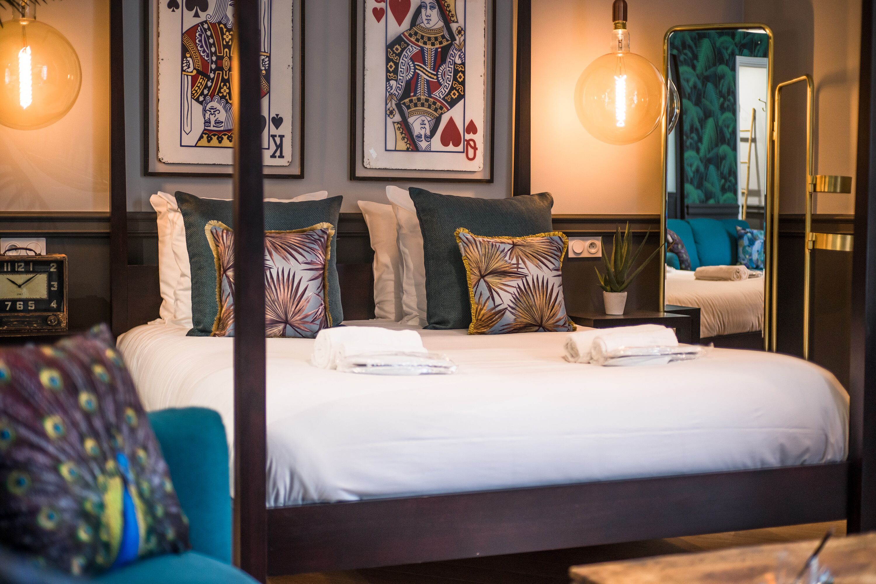 A neatly made bed with white linens, multiple pillows, and a bedside table with a lamp.