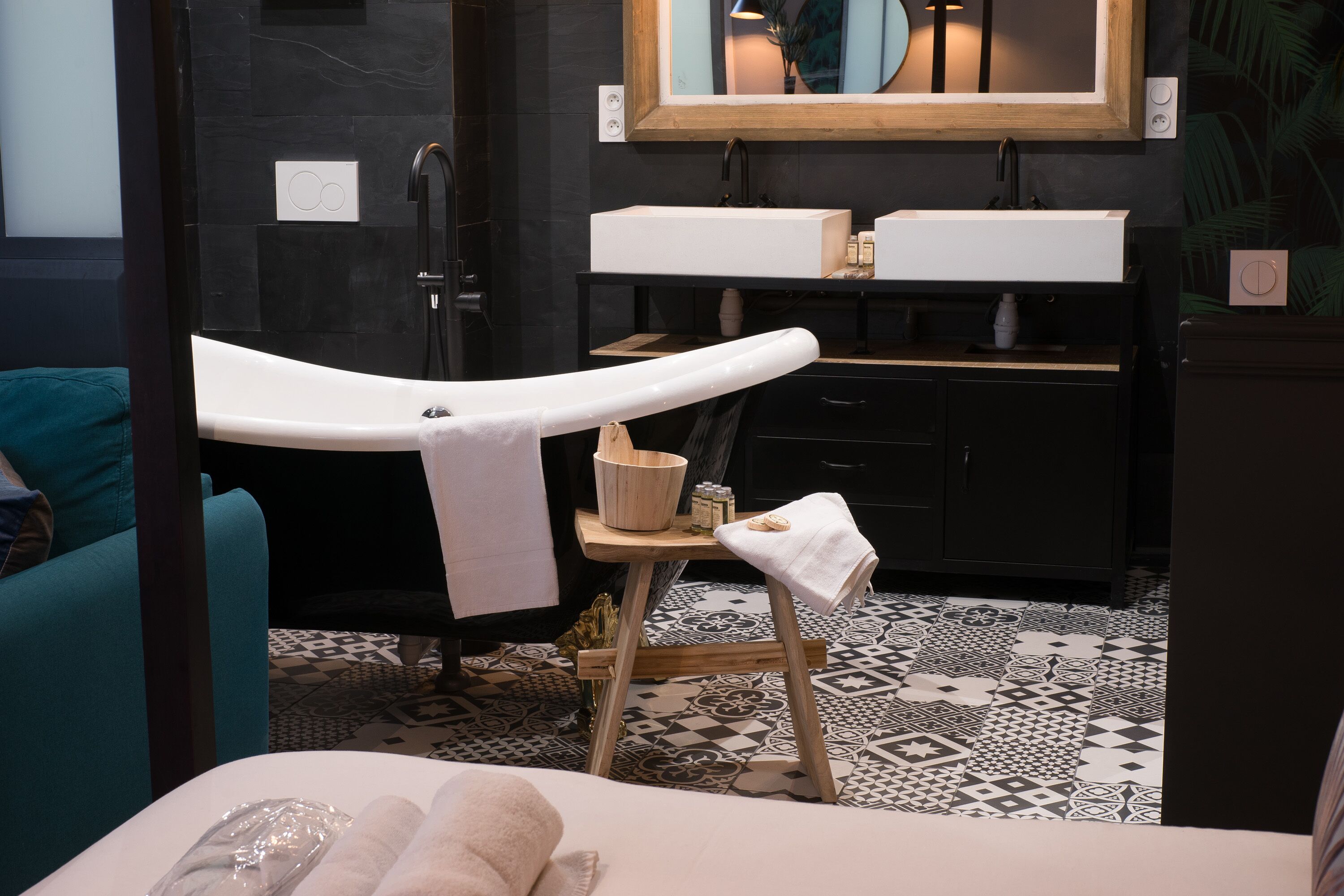 A bathroom with a bathtub, a wooden stool, a sink, and a mirror.