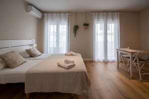 Ein Schlafzimmer mit einem Bett, einem Schreibtisch und zwei Fenstern mit Vorhängen.
