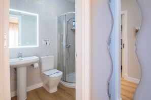 A bathroom with a sink, toilet, and glass shower enclosure. - The Rose Studio in Cadiz (Cádiz)