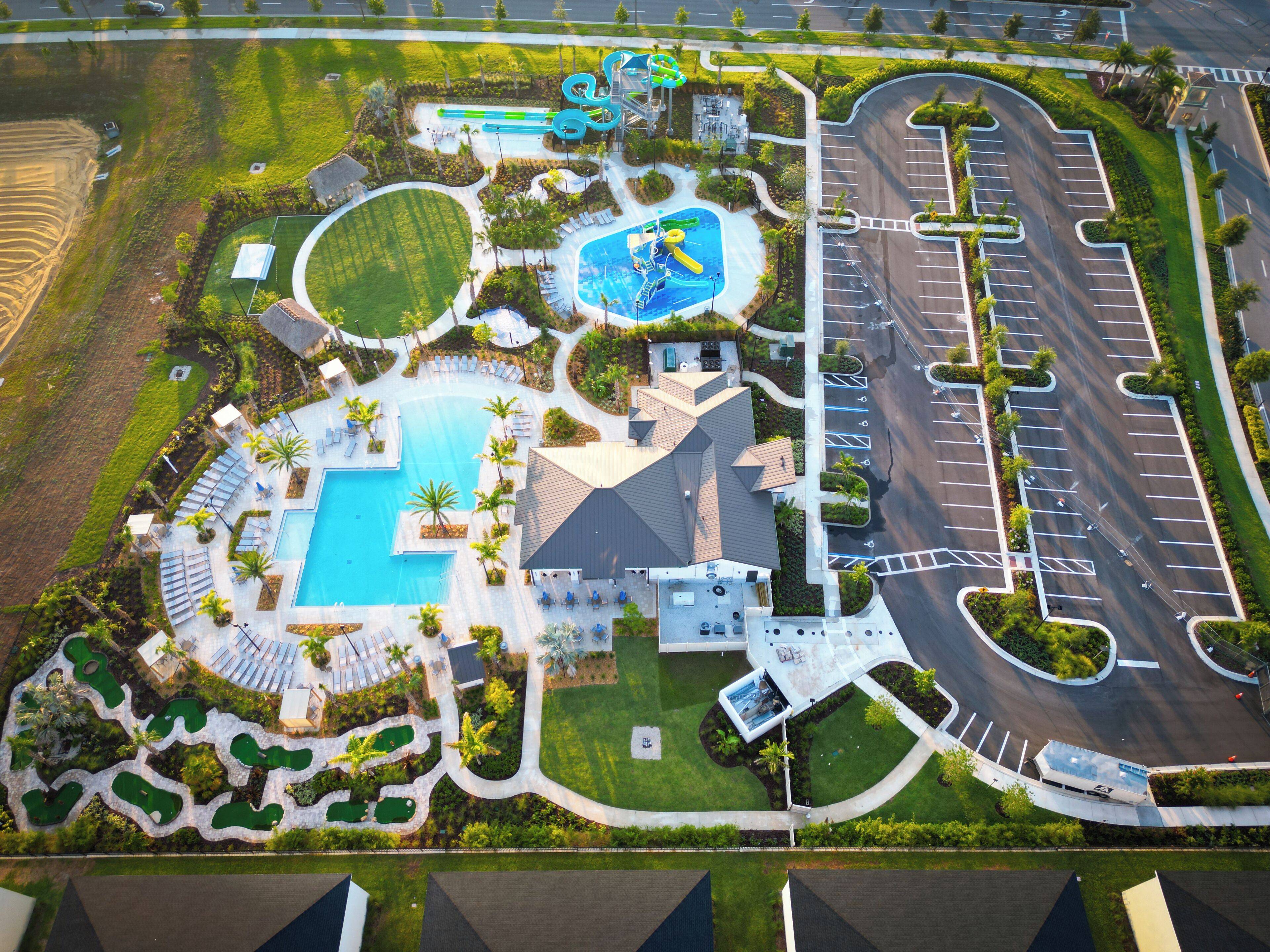 Vue aérienne d’un complexe hôtelier doté d’une piscine, de toboggans aquatiques et d’un parking.