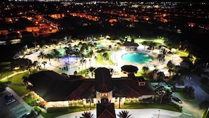 Vista aerea di un resort con piscina, un padiglione coperto e un paesaggio curato.