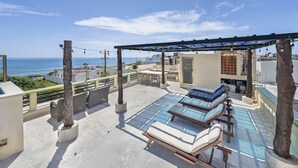 A rooftop terrace with sun loungers, a pergola, and a view of the ocean. - CASA KIM WHOLE HOUSE (Cancún)