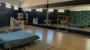 Ein geräumiges Zimmer mit großem Spiegel, einem Bett, einem Schreibtisch und einem Stuhl.